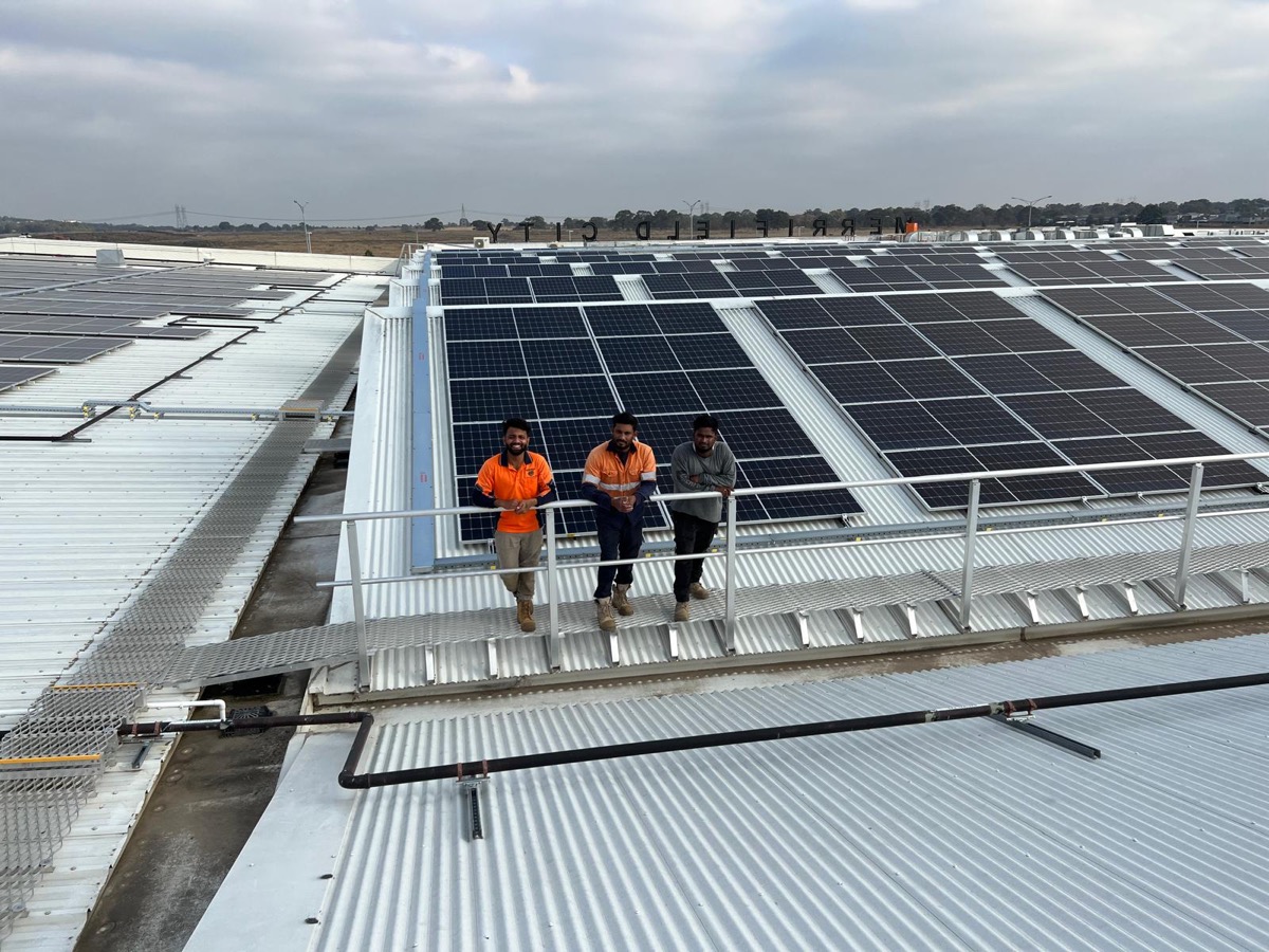 Three JM Solar installers in hi-vis on a rooftop
