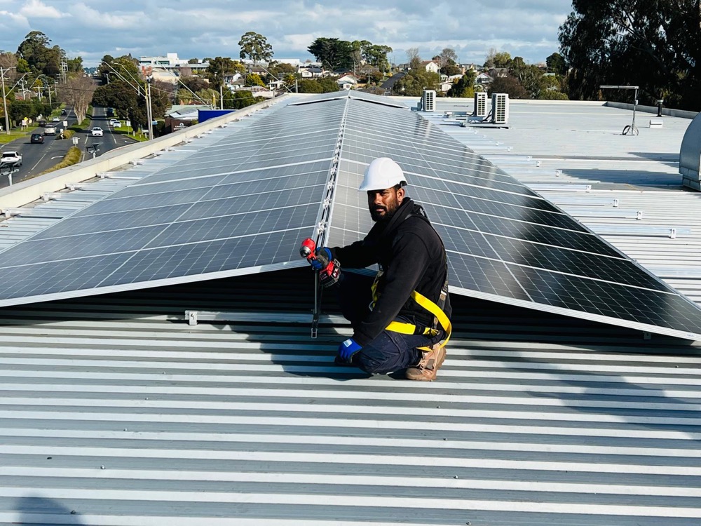 JM Solar installer harnessed and working on a roof